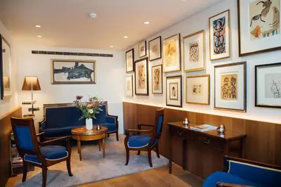 a waiting room with a table and chairs and pictures on the wall at Ambassade Hotel in Amsterdam