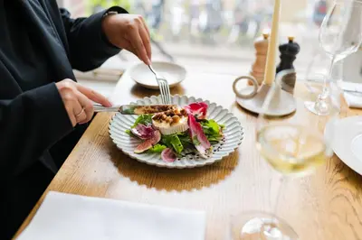 a person eating a plate of food on a table at Ambassade Hotel in Amsterdam