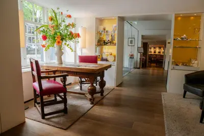 a dining room with a table and a vase of flowers at Ambassade Hotel in Amsterdam