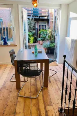 a table and chairs in a living room with a table at City-beach apartment nearby Amsterdam in Hoorn