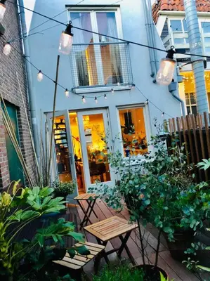 a garden with tables and chairs in front of a building at City-beach apartment nearby Amsterdam in Hoorn