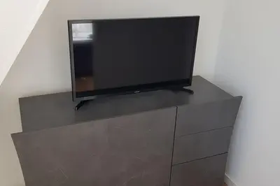 a flat screen tv sitting on top of a dresser at Katwijk Center, 1 min away from the beach! in Katwijk aan Zee