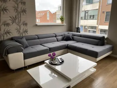 a living room with a couch and a coffee table at Katwijk Center, 1 min away from the beach! in Katwijk aan Zee