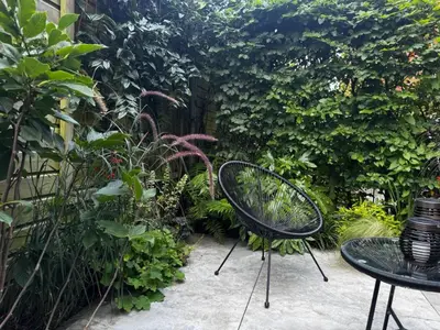 two chairs and a table in a garden at B&B Urban Oasis with Free Parking in Amsterdam
