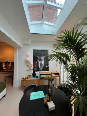 a living room with a black table and a skylight at B&B Urban Oasis with Free Parking in Amsterdam