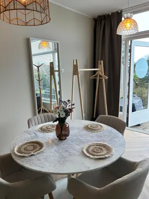 a dining room with a round table and chairs at Amsterdam Beach Apartment 33, Private Garden in Zandvoort