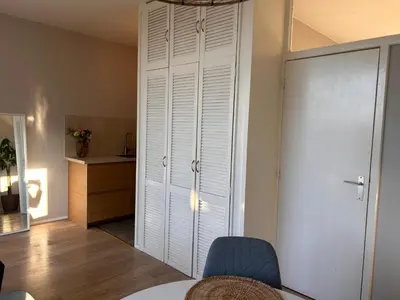 a white closet in a room with a table and chairs at Amsterdam Beach Apartment 17, incl Parking + Garden in Zandvoort