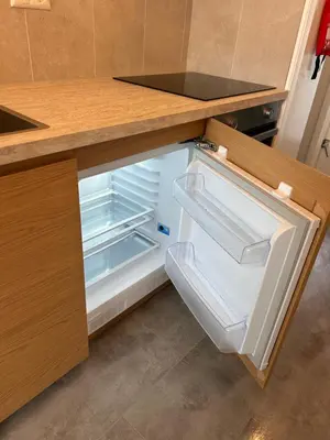 an empty refrigerator with its door open in a kitchen at Amsterdam Beach Apartment 17, incl Parking + Garden in Zandvoort