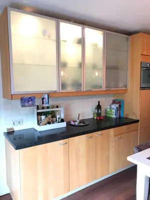 a kitchen with wooden cabinets and a black counter top at Great House for Two in Amsterdam in Amsterdam