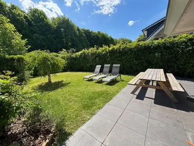 two chairs and a picnic table in a yard at The Poplar Place, Comfort & Hottub in Zeewolde