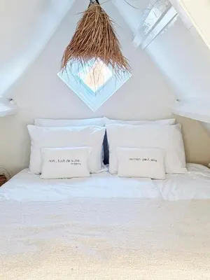 a white bed with two pillows on top of it at ELSK Cottage in Zandvoort
