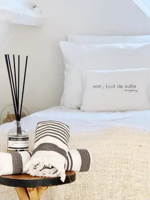 a bed with a tray with towels on it at ELSK Cottage in Zandvoort