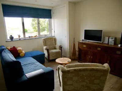 a living room with a couch and a tv at B&B “Te Warskip bij BlokVis” in Medemblik