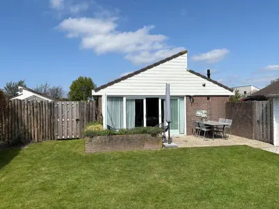 a white house with a table in a yard at Buenaventura in Egmond aan den Hoef