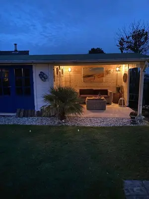 a house with a couch on a patio at night at Buenaventura in Egmond aan den Hoef