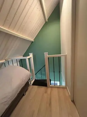 a bedroom with a bed and a stair case at Have a nice stay! - Vakantiehuis BijSaar in Noordwijk