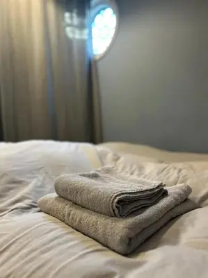 a pile of towels sitting on top of a bed at Have a nice stay! - Vakantiehuis BijSaar in Noordwijk