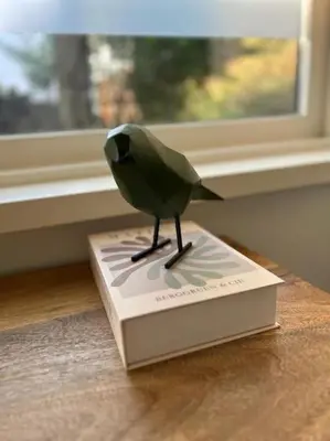 a bird statue sitting on top of a book at Have a nice stay! - Vakantiehuis BijSaar in Noordwijk