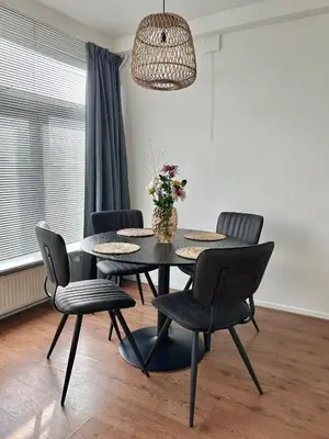 a dining room with a black table and chairs at Amsterdam Beach Apartment 50 - Basic, incl parking in Zandvoort
