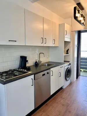 a kitchen with white cabinets and a sink and a dishwasher at Amsterdam Beach Apartment 50 - Basic, incl parking in Zandvoort