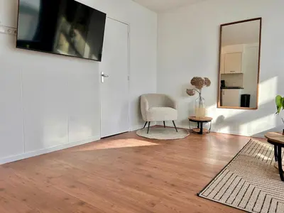 a living room with a chair and a television on a wall at Amsterdam Beach Apartment 50 - Basic, incl parking in Zandvoort