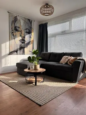 a living room with a black couch and a table at Amsterdam Beach Apartment 50 - Basic, incl parking in Zandvoort