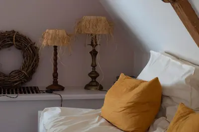 a bed with two lamps and a mirror on a table at Boutique Hotel Jongwijs Westzaan in Westzaan