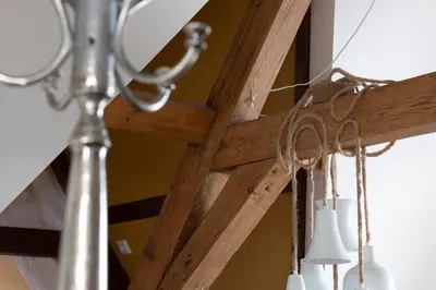 a chandelier with white candles hanging from a wooden beam at Boutique Hotel Jongwijs Westzaan in Westzaan