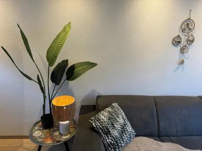 a living room with a couch and a table with a plant at Modern strandhuis 350 m van zee Egmond aan Zee in Egmond aan Zee