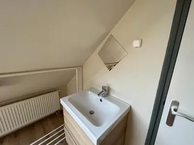 a bathroom with a white sink in a room at Modern strandhuis 350 m van zee Egmond aan Zee in Egmond aan Zee