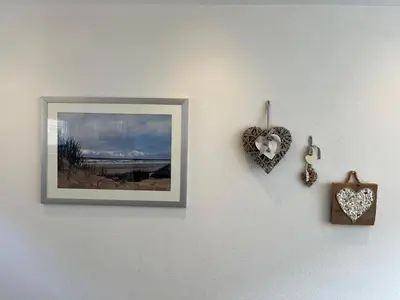 a picture on a wall with a heart and a clock at Modern strandhuis 350 m van zee Egmond aan Zee in Egmond aan Zee