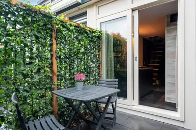 a table and chairs in front of a green wall at Loft 29 in Zandvoort