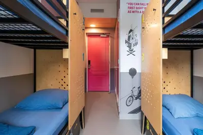 two beds in a dorm room with a red door at Stayokay Hostel Amsterdam Vondelpark in Amsterdam
