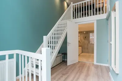 a white staircase in a home with blue walls at 1001 Nights Boutique Lofts in Haarlem