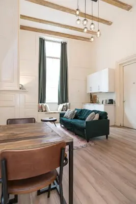 a living room with a table and a green couch at 1001 Nights Boutique Lofts in Haarlem