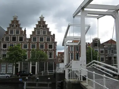 a bridge over a canal with buildings in the background at 1001 Nights Boutique Lofts in Haarlem