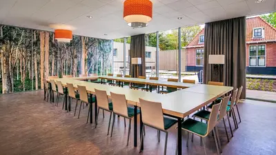 a conference room with a long table and chairs at Stayokay Hostel Soest in Soest