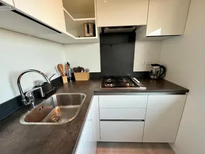 a kitchen with a sink and a stove at NEW - The Surf Shack - on a lake near Amsterdam! in Vinkeveen