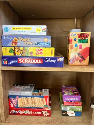 a book shelf filled with lots of childrens games at NEW - The Surf Shack - on a lake near Amsterdam! in Vinkeveen
