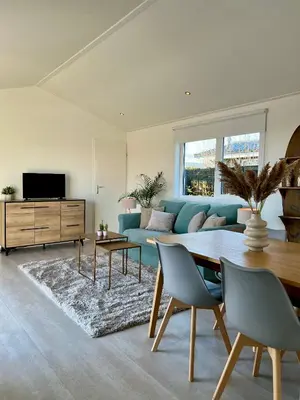 a living room with a blue couch and a table at NEW - The Surf Shack - on a lake near Amsterdam! in Vinkeveen