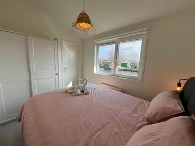 a bedroom with a bed with a stuffed animal on it at NEW - The Surf Shack - on a lake near Amsterdam! in Vinkeveen
