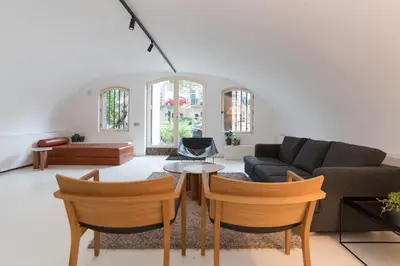 a living room with a couch and a table and chairs at Wellness Apartment on the Wharf Utrecht in Utrecht