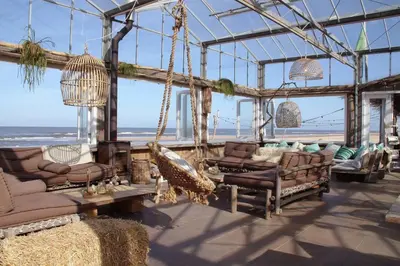 a living room with couches and chairs and the beach at Hendrika Apartments in Zandvoort