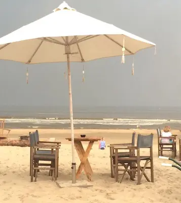 a table and chairs under an umbrella on the beach at Hendrika Apartments in Zandvoort