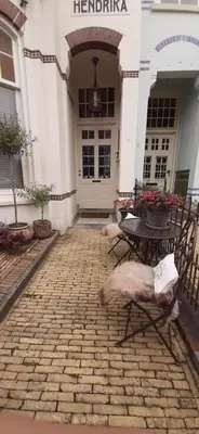 a building with a table and chairs in front of it at Hendrika Apartments in Zandvoort