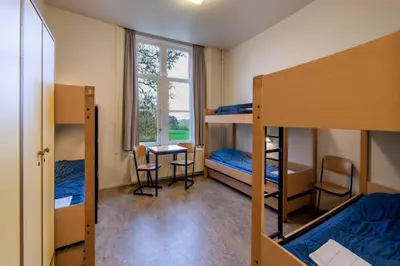 a dorm room with bunk beds and a desk at Stayokay Hostel Utrecht - Bunnik in Bunnik