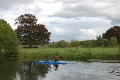 two people in a blue canoe on a river at Stayokay Hostel Utrecht - Bunnik in Bunnik