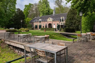 a group of tables and chairs in front of a building at Stayokay Hostel Utrecht - Bunnik in Bunnik