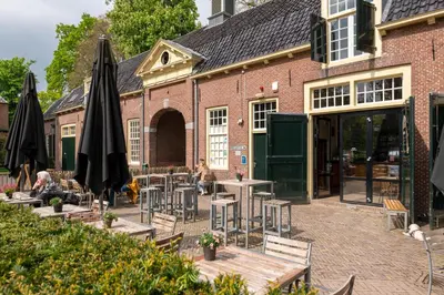 an outdoor patio with tables and chairs and umbrellas at Stayokay Hostel Utrecht - Bunnik in Bunnik