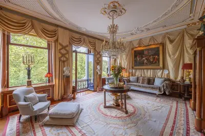 a living room with a couch and a chandelier at Park Mansion Hotel in Amsterdam